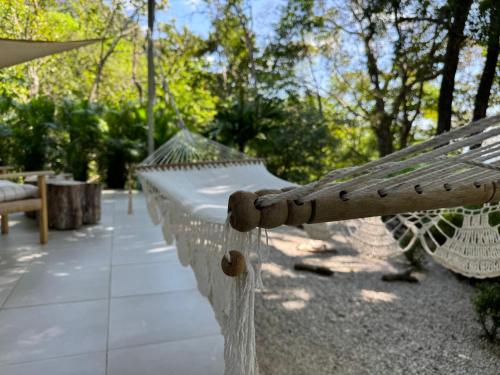 a white hammock sitting on a patio at Amaj Eco Lodge in Sámara