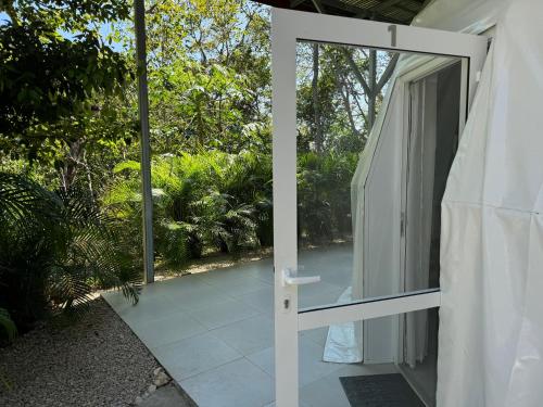 a glass door leading to a patio with trees at Amaj Eco Lodge in Sámara