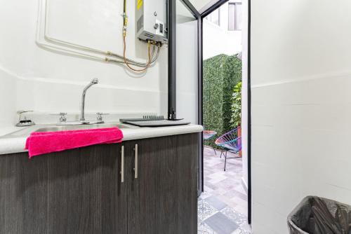 a bathroom with a sink and a pink towel at Narvarte Apartments by Escajal Homes in Mexico City