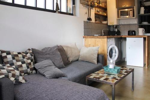 a living room with a couch and a table at Practical and charming love cocoon with garden in Pierrefitte-sur-Seine