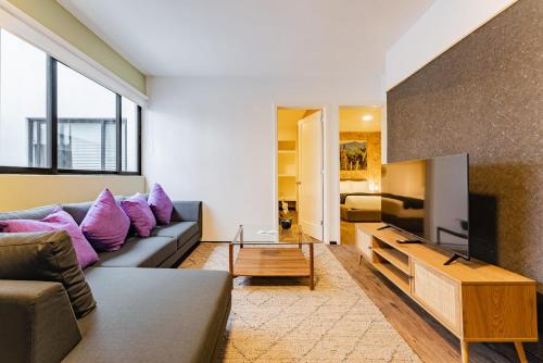 a living room with a gray couch and purple pillows at Narvarte Apartments by Escajal Homes in Mexico City