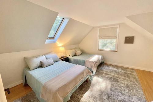 2 camas num quarto no sótão com uma janela em Quiet Family Friendly Home w/ Backyard [Owls Nest] em Tremont