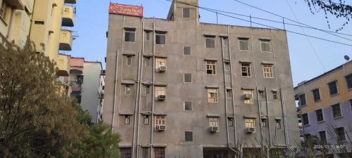 um velho edifício cinzento com janelas numa cidade em OYO Hotel Swarna Palace em Patna