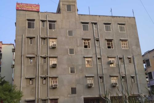 um edifício alto com janelas e uma placa no topo em OYO Hotel Swarna Palace em Patna