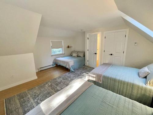 a attic bedroom with two beds and a window at Quiet Family Friendly Home w/ Backyard [Owls Nest] in Tremont