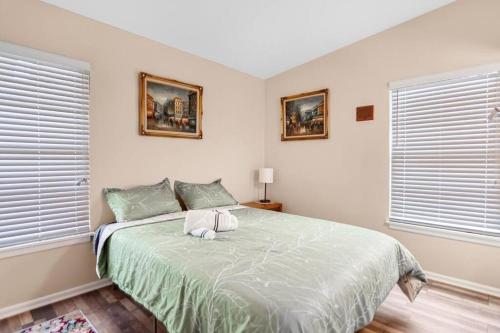 a bedroom with a large bed with two windows at Fenced backyard, king bed, near medical center, Aquarium, and SeaWorld in San Antonio