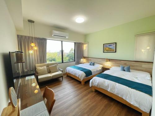 a hotel room with two beds and a couch at Taroko 767 Farm B&B 太魯閣767農莊民宿 in Xiulin
