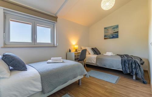 een slaapkamer met 2 bedden, een bureau en een raam bij 3 Bedroom Nice Home In Krsan in Kršan