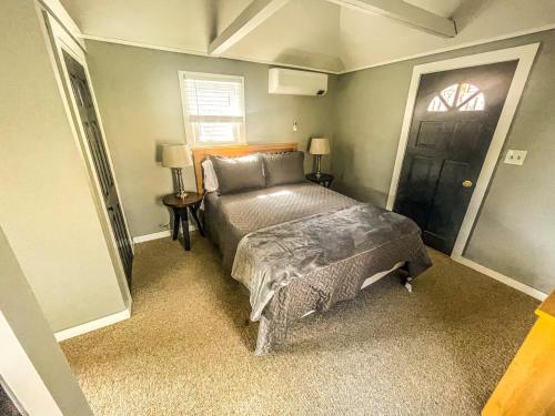 sypialnia z łóżkiem i czarnymi drzwiami w obiekcie Cozy Pond Side Cottage in Bar Harbor! [The Nook] w mieście Bar Harbor