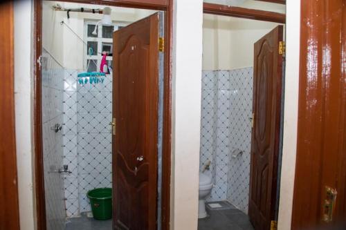 a bathroom with two wooden doors and a toilet at Denverwing Homes in Eldoret
