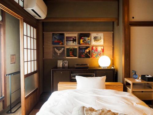 sypialnia z łóżkiem i stołem z lampką w obiekcie ゲストホテル宰嘉庵あおい/GuestHotelSAIKAAN_AOI w mieście Maizuru