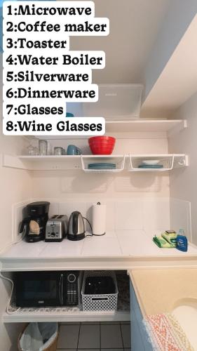 a kitchen with a shelf with a microwave and wine glasses at Big Island Retreat - No Resort Fees in Kailua-Kona