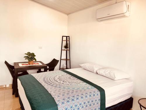 een kleine slaapkamer met een bed en een bureau bij Nomada's Digital in Manuel Antonio