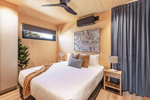 een slaapkamer met een bed en een plafondventilator bij Reflections Hawks Nest - Holiday Park in Hawks Nest