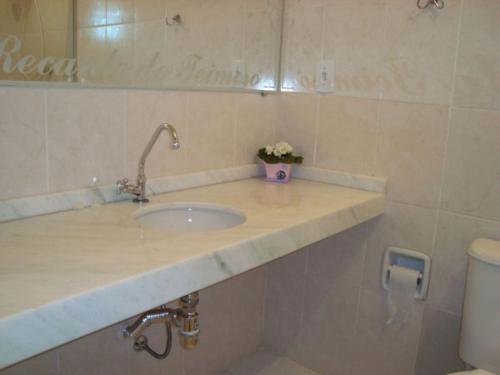 a bathroom with a sink and a toilet at Pousada Recanto do Teimoso in Ubatuba
