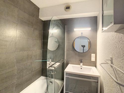 une salle de bain avec un lavabo, une baignoire et un miroir dans l'établissement Charmant 2 pièces + coin cabine, proche centre Combloux, RDJ, terrasse, parking et casier à skis - FR-1-560-69, à Combloux