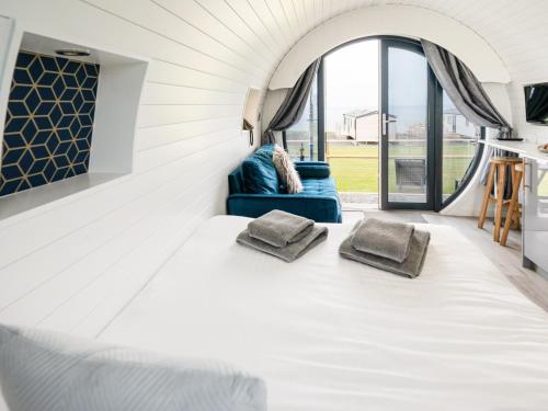 a white room with a bed and a couch at Ynys Pod - Uk46078 in Gwbert