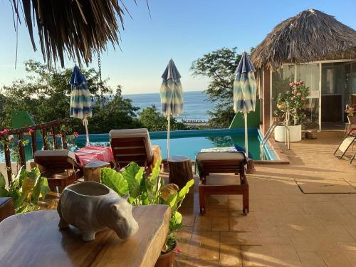 uma mesa com uma estátua de um porco em cima de um pátio em Namasté Zipolite Suites em Zipolite