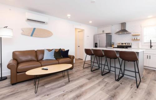 a living room with a couch and a table and a kitchen at Ocean Lofts in the Vibe #2 - 5 min walk to beach in Virginia Beach