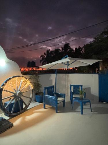 een patio met 2 stoelen, een parasol en een wiel bij Villa Aqua Boutique Vichayito in Vichayito