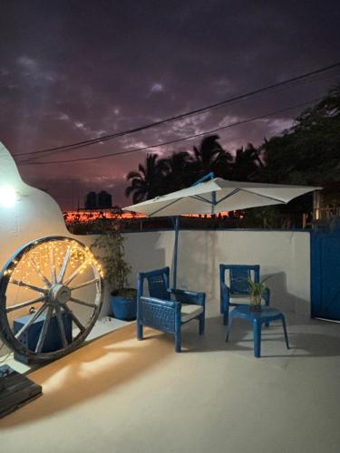 un patio con 2 sillas, una sombrilla y una rueda en Villa Aqua Boutique Vichayito, en Vichayito