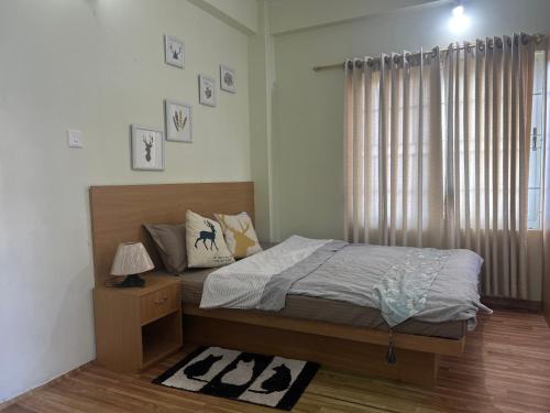 a bedroom with a large bed and a window at Zion Apartments, Pokhara in Pokhara