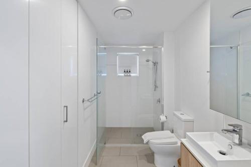 uma casa de banho com um chuveiro, um WC e um lavatório. em Peaceful One Bedroom Residence with Parking em Brisbane