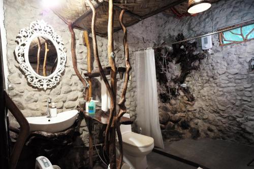 ein Steinbad mit einem Waschbecken und einem WC in der Unterkunft Banahaw Circle Nature Retreat 