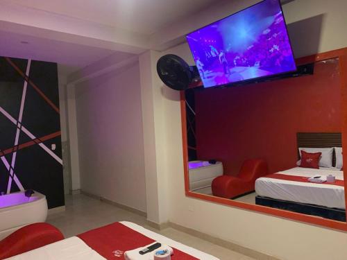 a bedroom with a mirror and a tv on the wall at Hotel picasso in Piura