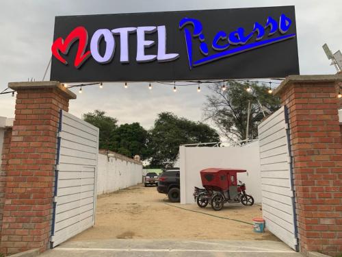 a sign over a garage with a motor cart in it at Hotel picasso in Piura