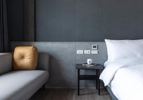 um quarto com uma cama, um sofá e uma mesa em Hotel Euphemia em Taichung