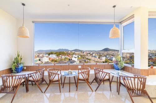 a dining room with tables and chairs and a large window at The Grandview Villa Dalat in Da Lat