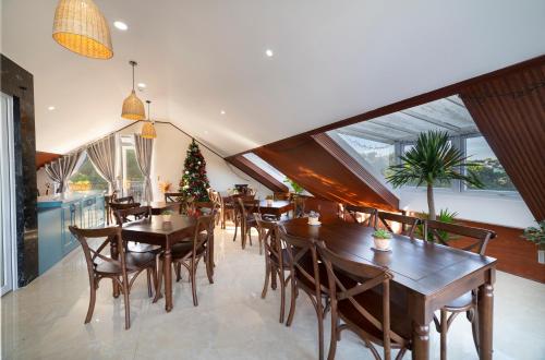 a dining room with tables and chairs and a christmas tree at The Grandview Villa Dalat in Da Lat