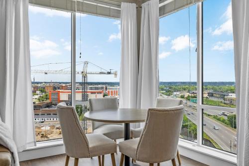 a dining room with a table and chairs and large windows at The Malibu Suite Penthouse The Gulch in Nashville