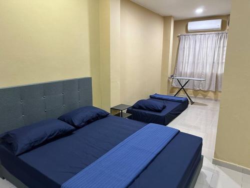 1 dormitorio con 2 camas y almohadas azules en ~Big House UITM Hospital 11 Pax~, en Shah Alam