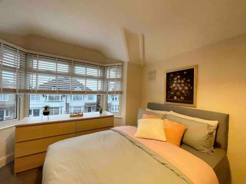 Un dormitorio con una cama grande y una ventana en Cosy House near Harry Potter Studios, en Leavesden Green