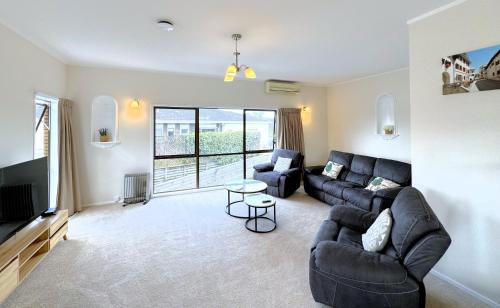 a living room with a couch and a tv at Spacious retreat with Mountain View in Rotorua