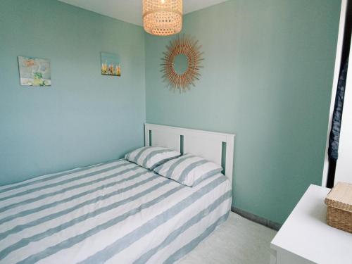 - une chambre avec un lit rayé et un miroir dans l'établissement Appartement T2 avec garage et piscine à Sète - FR-1-338-484, à Sète