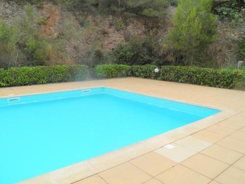 une grande piscine bleue sur un patio carrelé dans l'établissement Appartement T2 avec garage et piscine à Sète - FR-1-338-484, à Sète