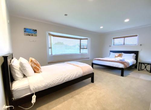 羅托魯阿的住宿－Spacious retreat with Mountain View，一间卧室设有两张床和窗户。