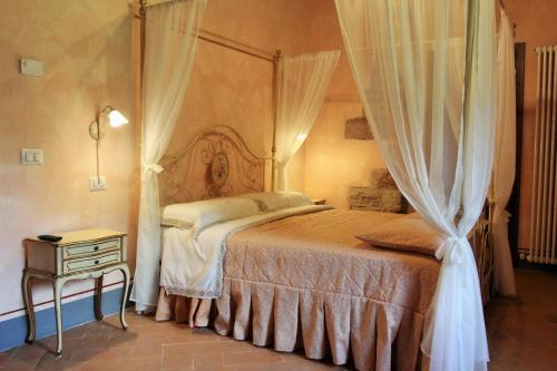 a bedroom with a canopy bed and a night stand at Agriturismo Casale La Palombara in Cerreto di Spoleto