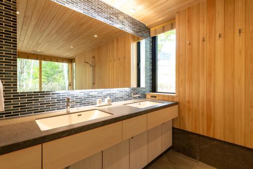 a bathroom with two sinks and a large mirror at Yuzen in Kutchan