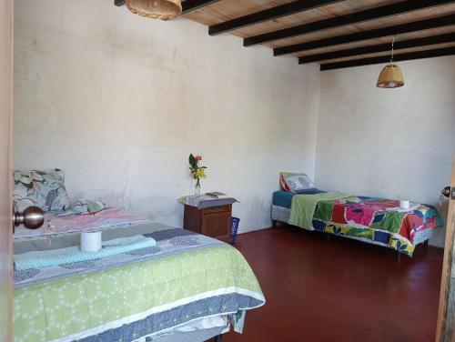 a room with two beds and a table with a bed sqor at Cabaña Tzanjuyu in San Juan La Laguna