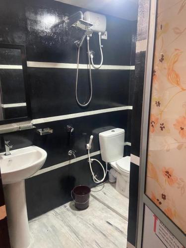 Un baño con lavabo, inodoro y ducha. en Sandcastle Villa, en Weligama
