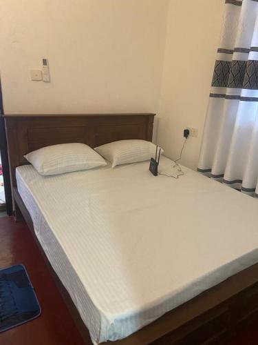 1 dormitorio con 1 cama grande con sábanas blancas en Sandcastle Villa en Weligama