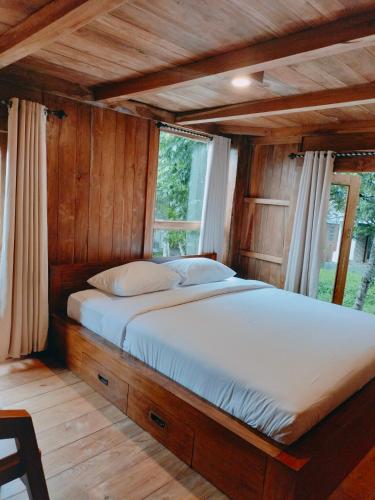 a large bed in a room with wooden walls at Villa Da- Hee in Bandungan