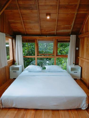 a large bed in a room with windows at Villa Da- Hee in Bandungan