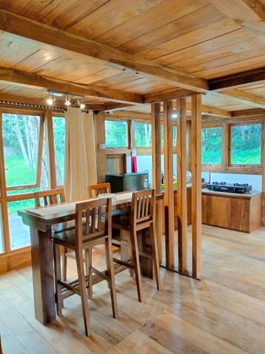 een keuken en eetkamer met een houten tafel en stoelen bij Villa Da- Hee in Bandungan