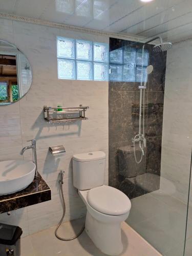 een badkamer met een toilet, een douche en een wastafel bij Villa Da- Hee in Bandungan