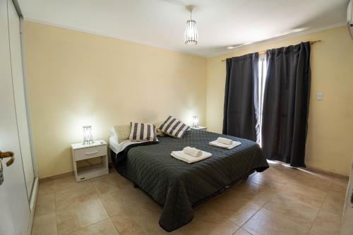 ein Schlafzimmer mit einem Bett mit zwei Handtüchern darauf in der Unterkunft Dúplex Vista Verde in Belén